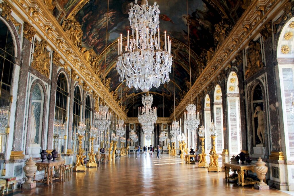 an empty hall of mirrors, a large chandelier in the center