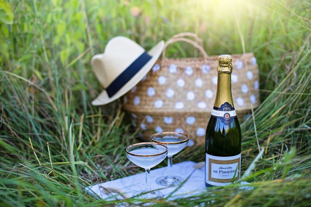 picnic in versailles' grass, bottle of champagne and a pair of glasses