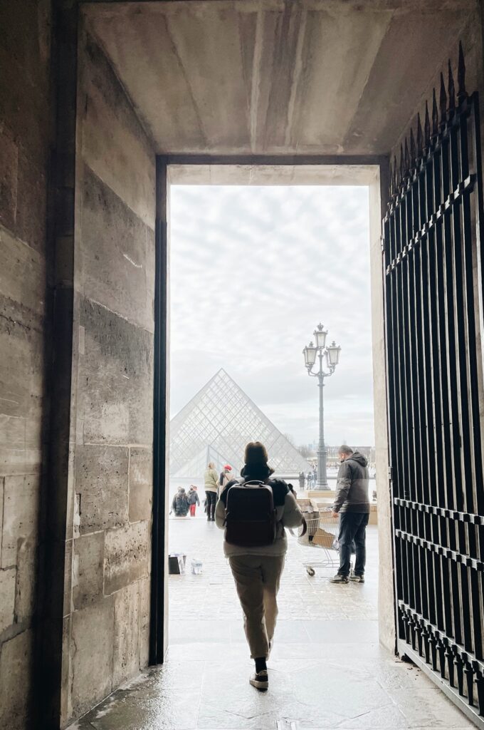 person walking towards the louvre