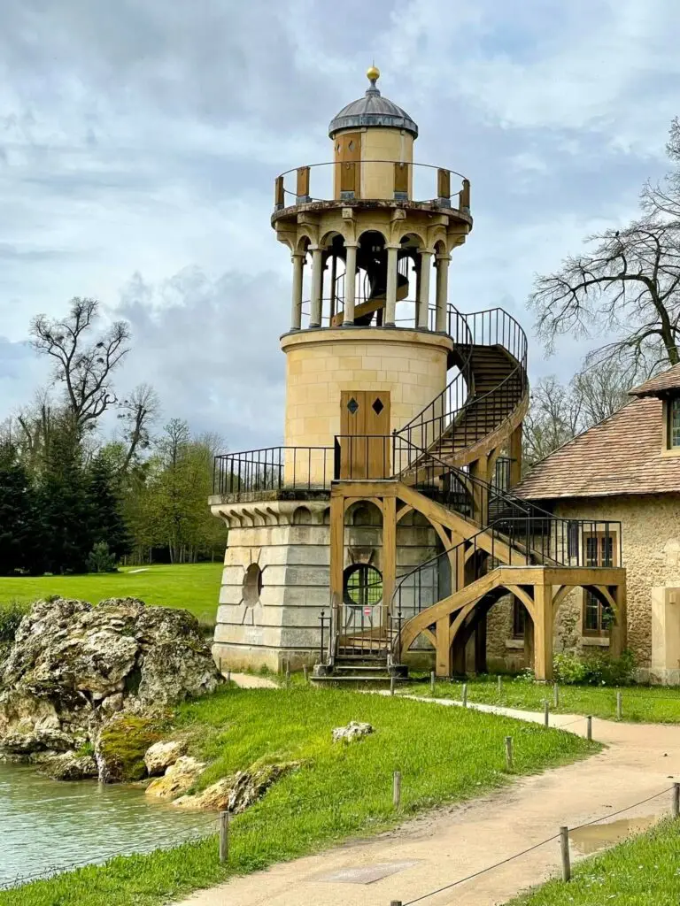 "Detailed view of the Marlborough Tower in the Queen’s Hamlet at Versailles, with spiral staircase and columned lookout above the water's edge.