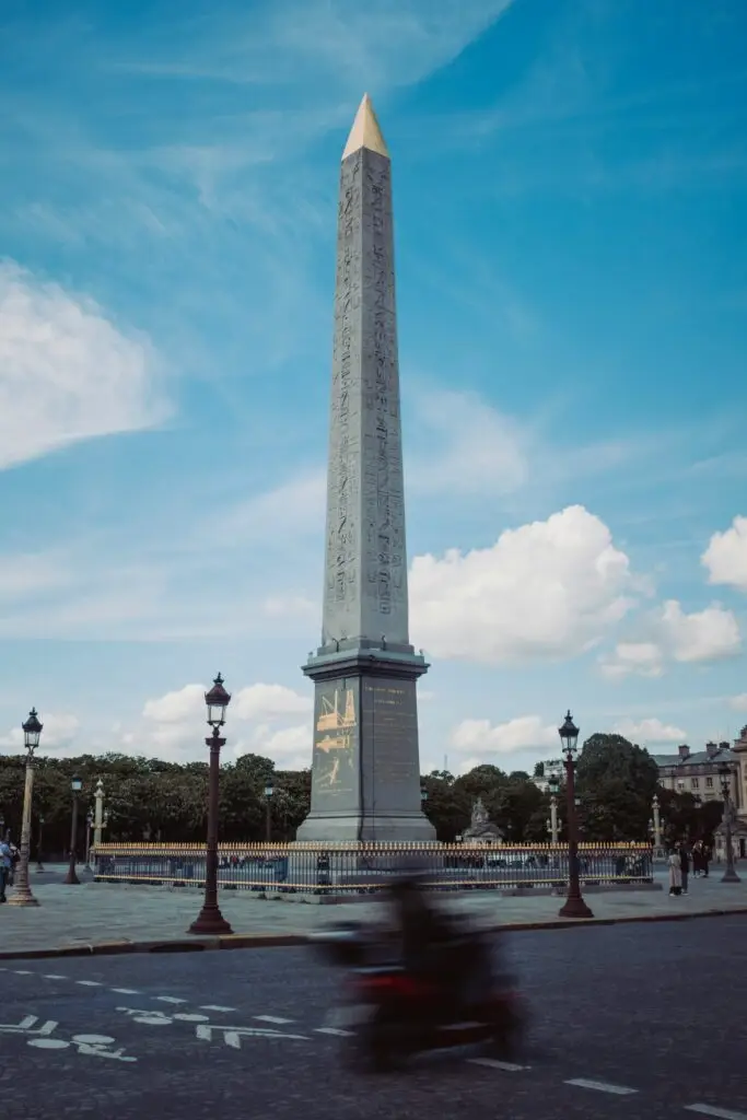 "The Luxor Obelisk stands tall in the center of Place de la Concorde, Paris, under a vivid blue sky. Once the site of the guillotine during the French Revolution, this square marks the tragic end of Marie Antoinette's life—an essential stop when walking in the footsteps of the ill-fated queen.
