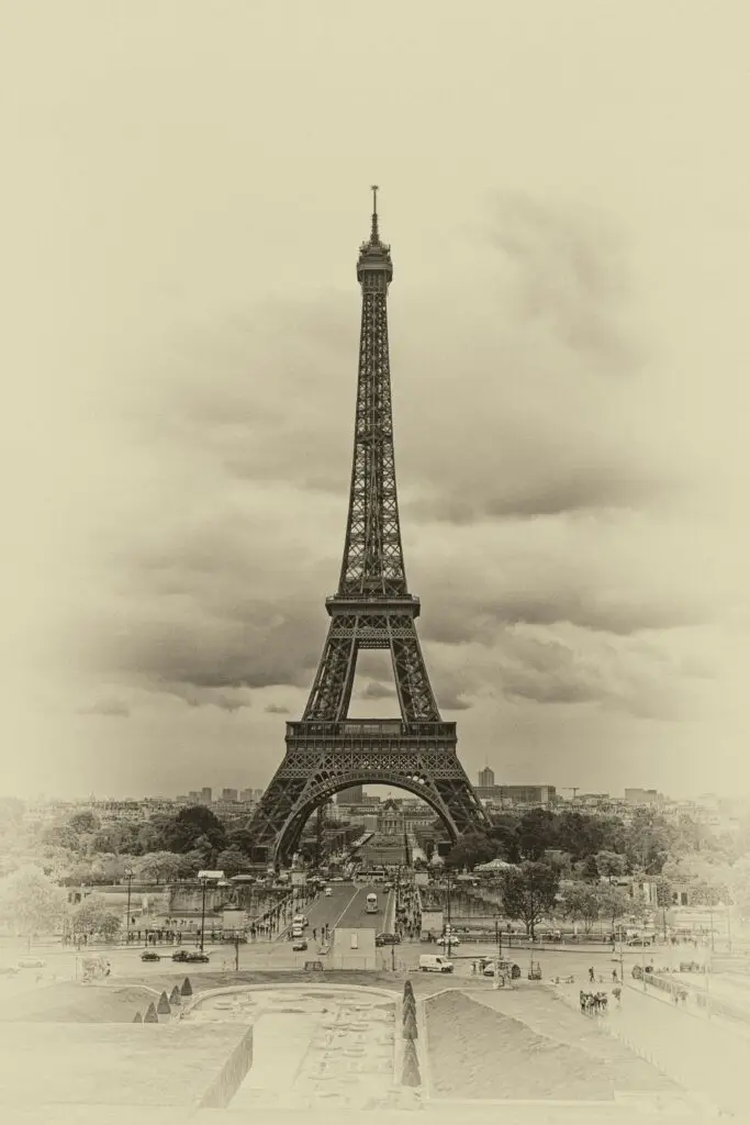 Vintage-style sepia photograph of the Eiffel Tower seen from the Trocadéro, evoking early 20th-century Paris when the tower was still controversial among critics.