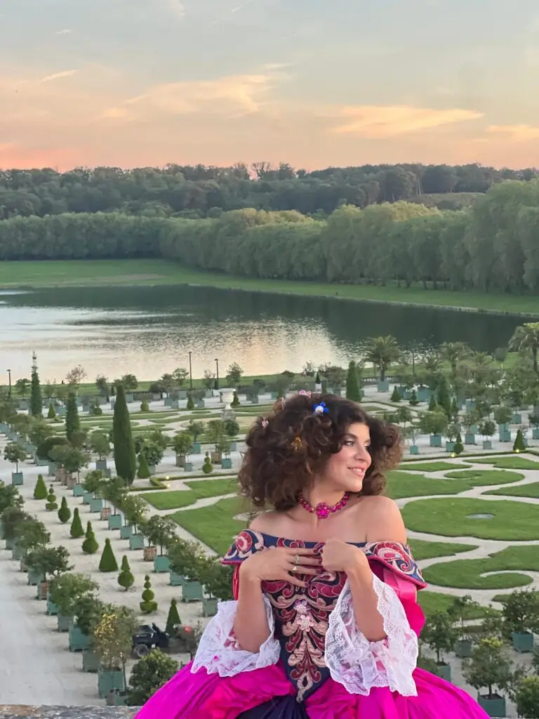 Tara Lengyel in costume, Versailles gardens in background